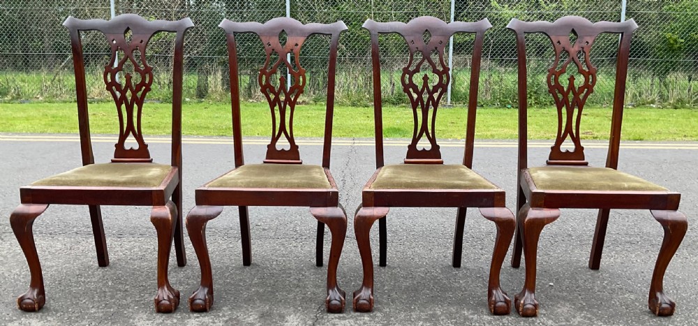 A set of four Chippendale style mahogany dining chairs with carved pierced back splats, olive fabric drop-in seats, and cabriole front legs ending in ball and claw feet. View II