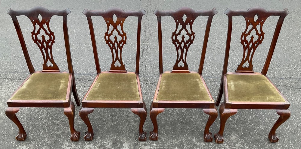 A set of four Chippendale style mahogany dining chairs with carved pierced back splats, olive fabric drop-in seats, and cabriole front legs ending in ball and claw feet. View III