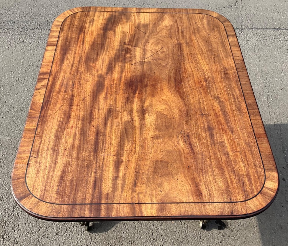 A Georgian mahogany tilt-top breakfast table featuring a crossbanded border, fine inlay stringing, and reeded quadruped legs ending in brass claw feet with castors. View XII