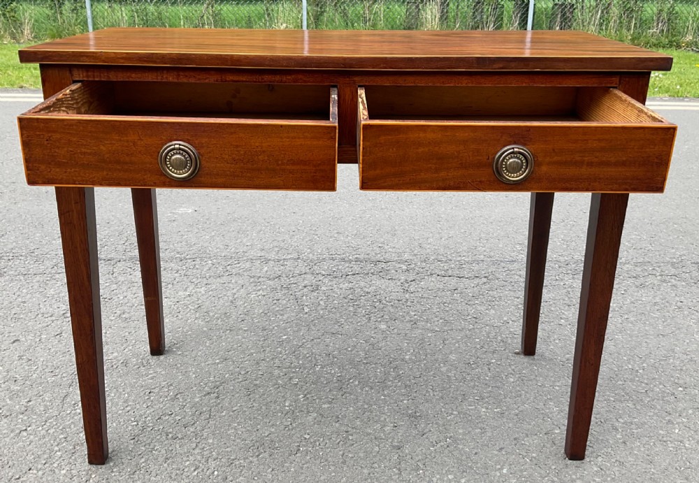 A Georgian mahogany side table featuring two drawers with brass ring handles and straight tapered legs. View IV