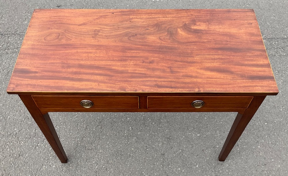 A Georgian mahogany side table featuring two drawers with brass ring handles and straight tapered legs. View V