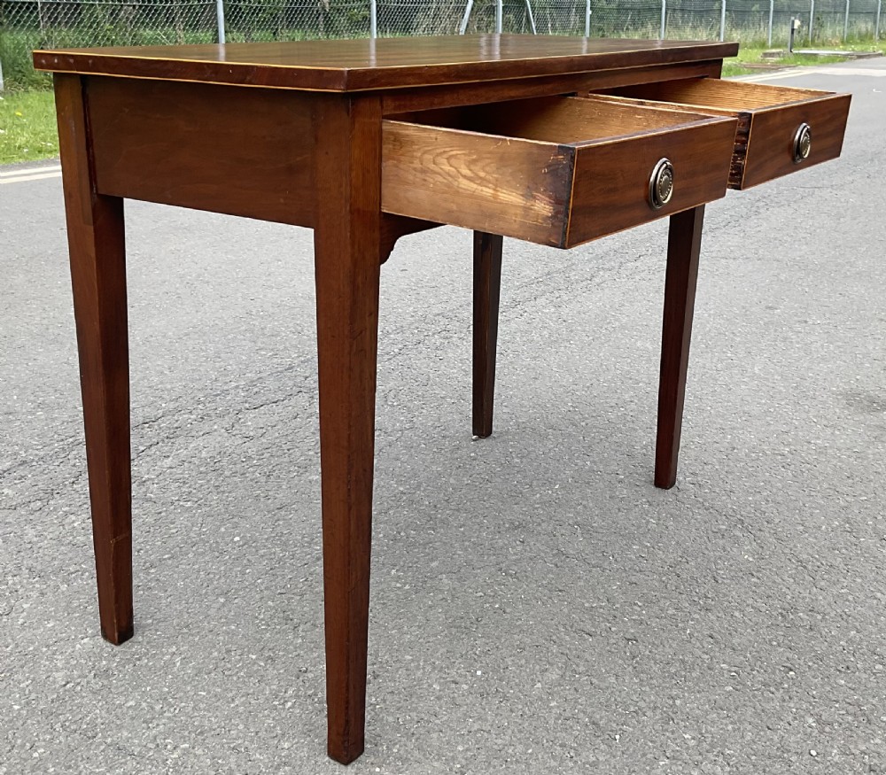A Georgian mahogany side table featuring two drawers with brass ring handles and straight tapered legs. View VII