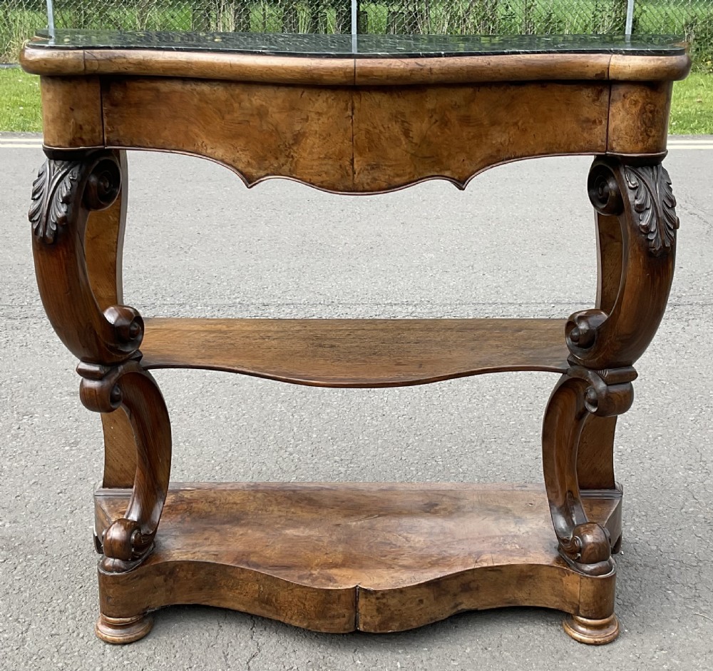 A Victorian serpentine-front console table crafted from figured wood with a dark green marble top and carved scroll legs. View III