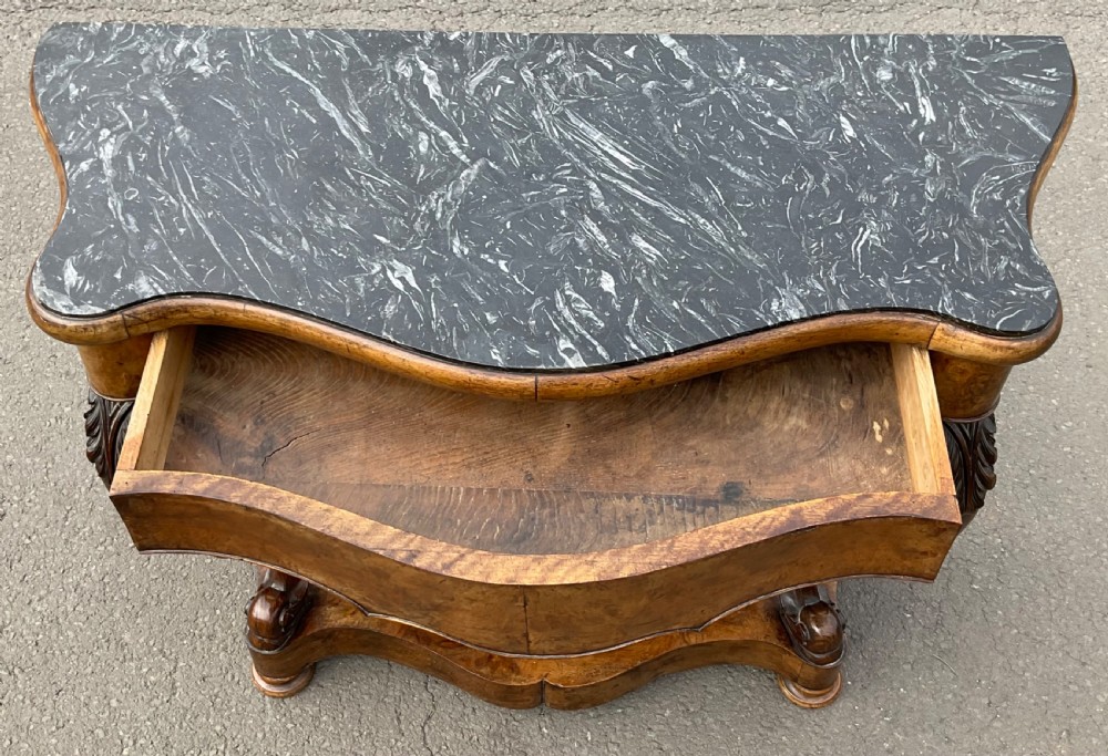 A Victorian serpentine-front console table crafted from figured wood with a dark green marble top and carved scroll legs. View VIII
