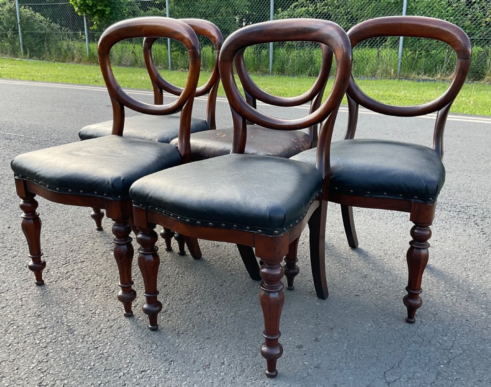 A set of five Victorian mahogany dining chairs featuring rounded balloon backrests, dark leather upholstered seats, and turned front legs. View III