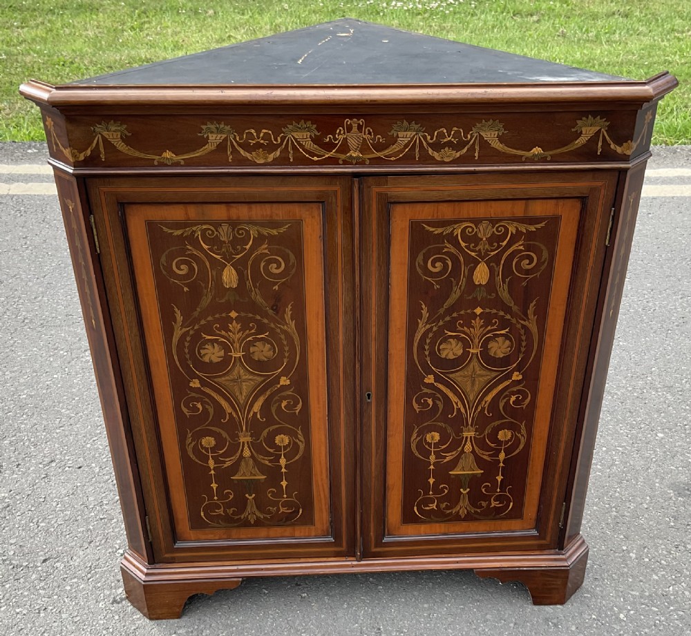 An Edwardian inlaid mahogany standing corner cabinet featuring a broken pediment, astragal glazed upper doors, and marquetry inlaid lower panels. View VII