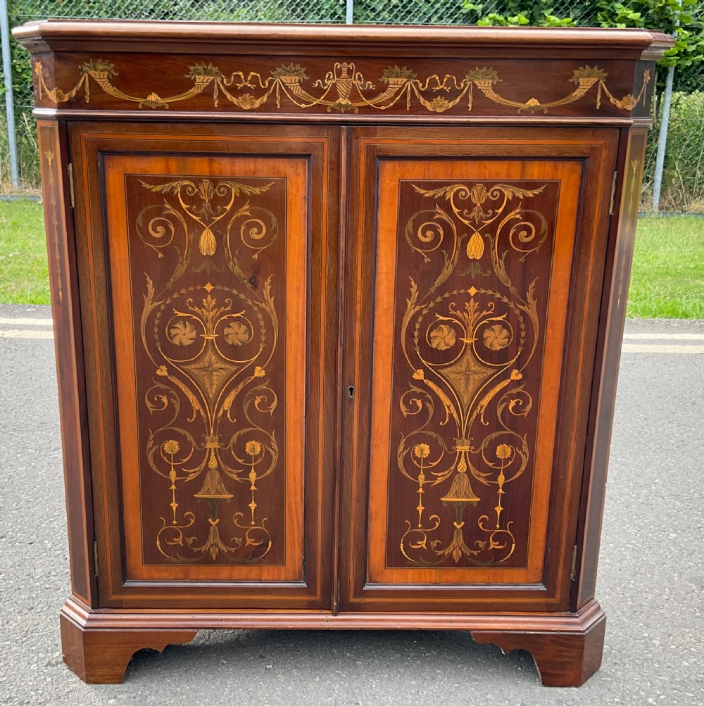 An Edwardian inlaid mahogany standing corner cabinet featuring a broken pediment, astragal glazed upper doors, and marquetry inlaid lower panels. View VIII