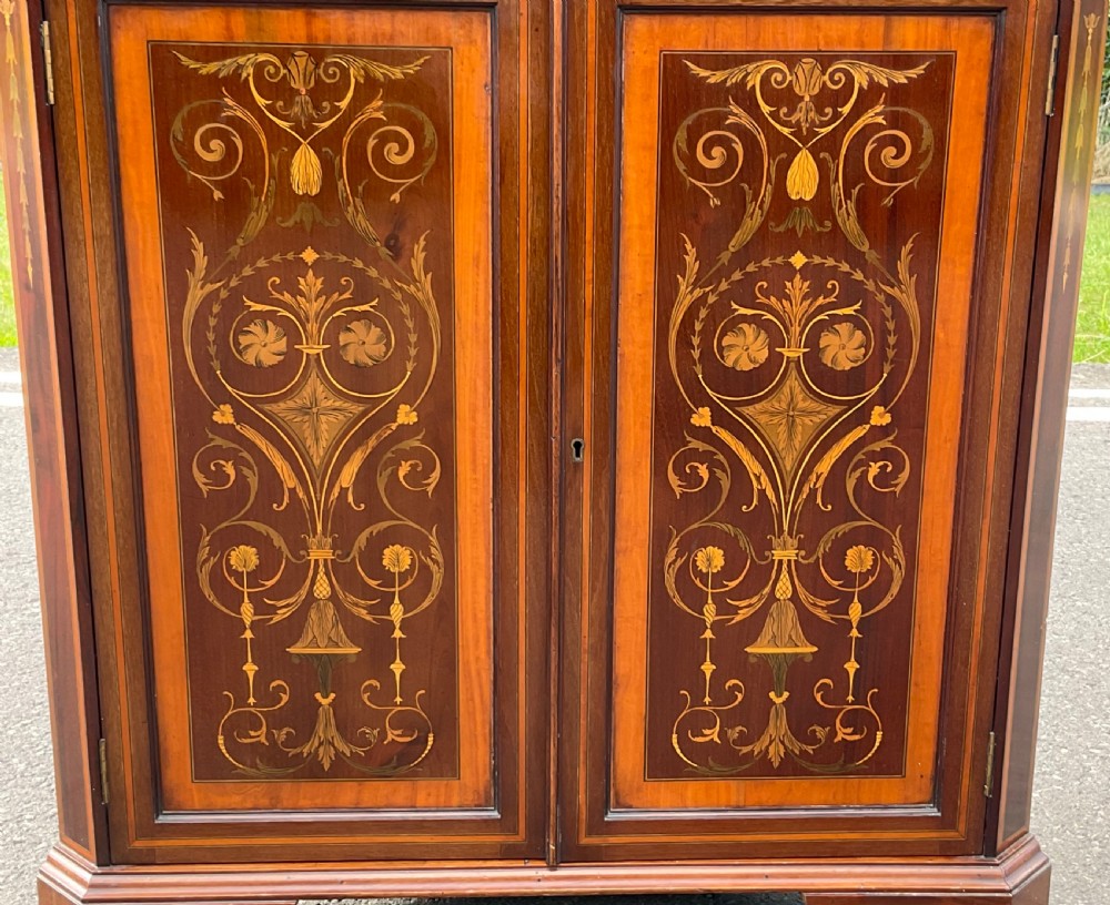 An Edwardian inlaid mahogany standing corner cabinet featuring a broken pediment, astragal glazed upper doors, and marquetry inlaid lower panels. View XI