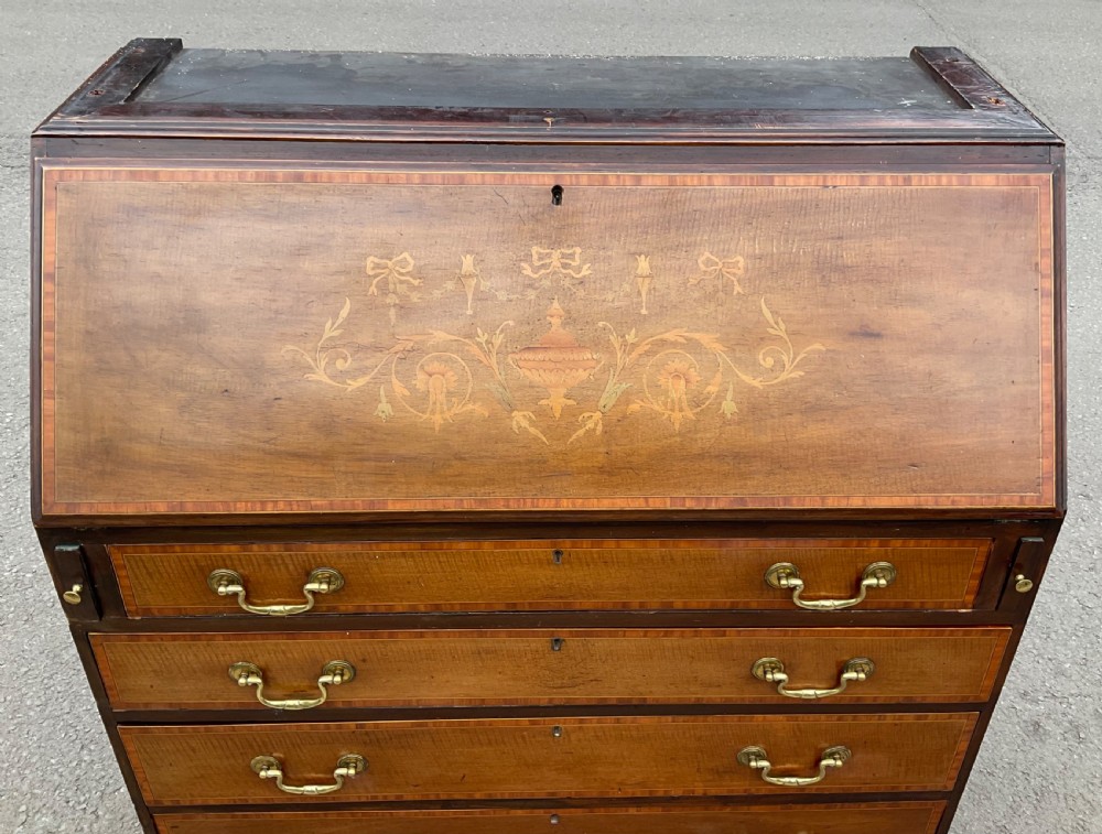An Edwardian inlaid mahogany bureau bookcase featuring a two-door astragal glazed upper cabinet above a fall-front writing desk and four long drawers. View VIII