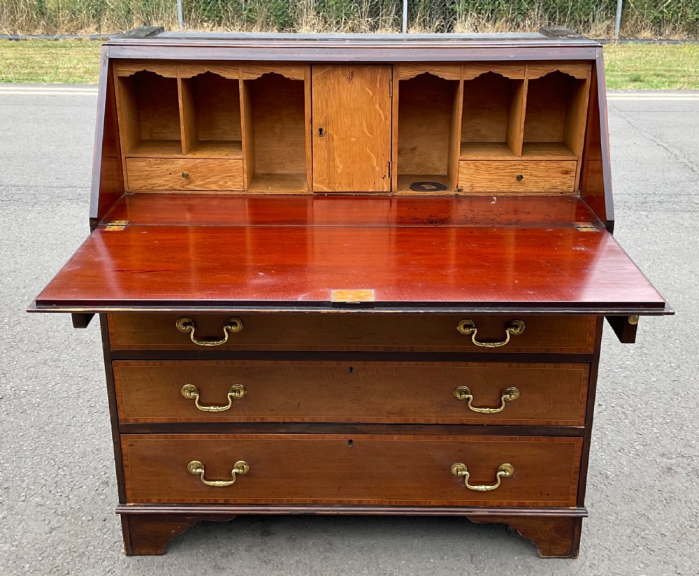 An Edwardian inlaid mahogany bureau bookcase featuring a two-door astragal glazed upper cabinet above a fall-front writing desk and four long drawers. View X