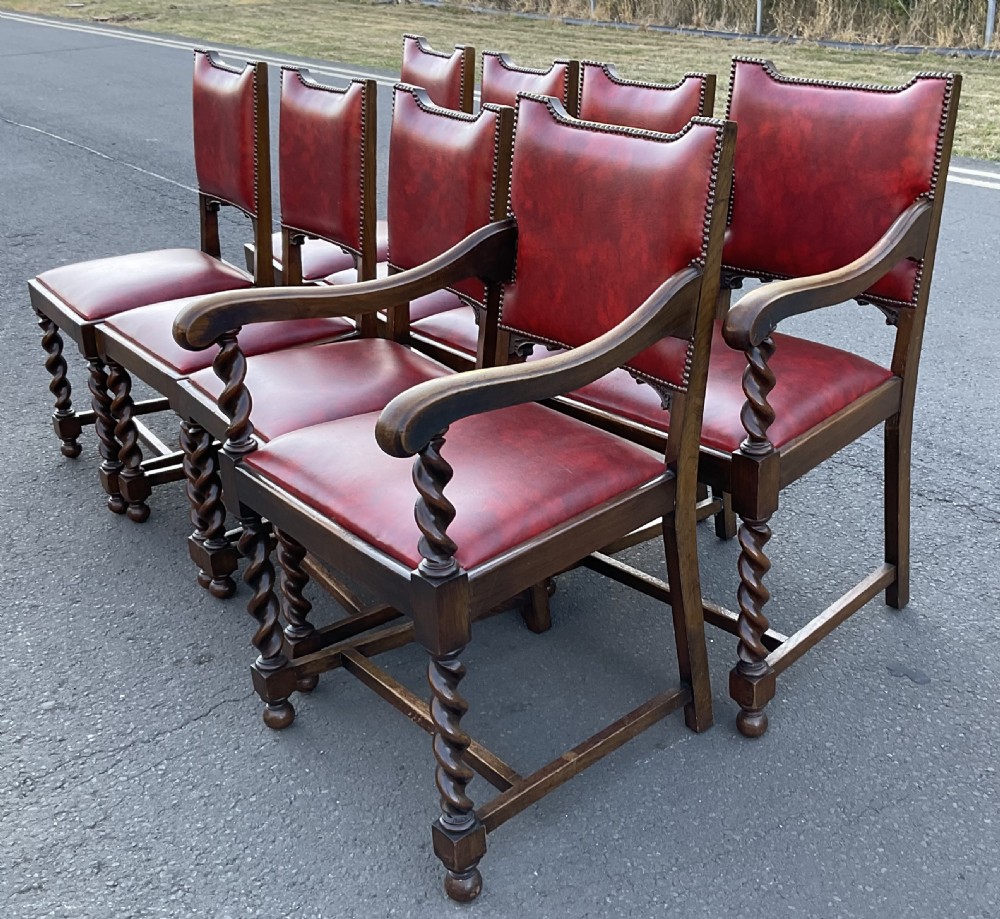 A set of eight oak dining chairs featuring red leather upholstery with brass stud detailing and spiral barley twist legs. View IV