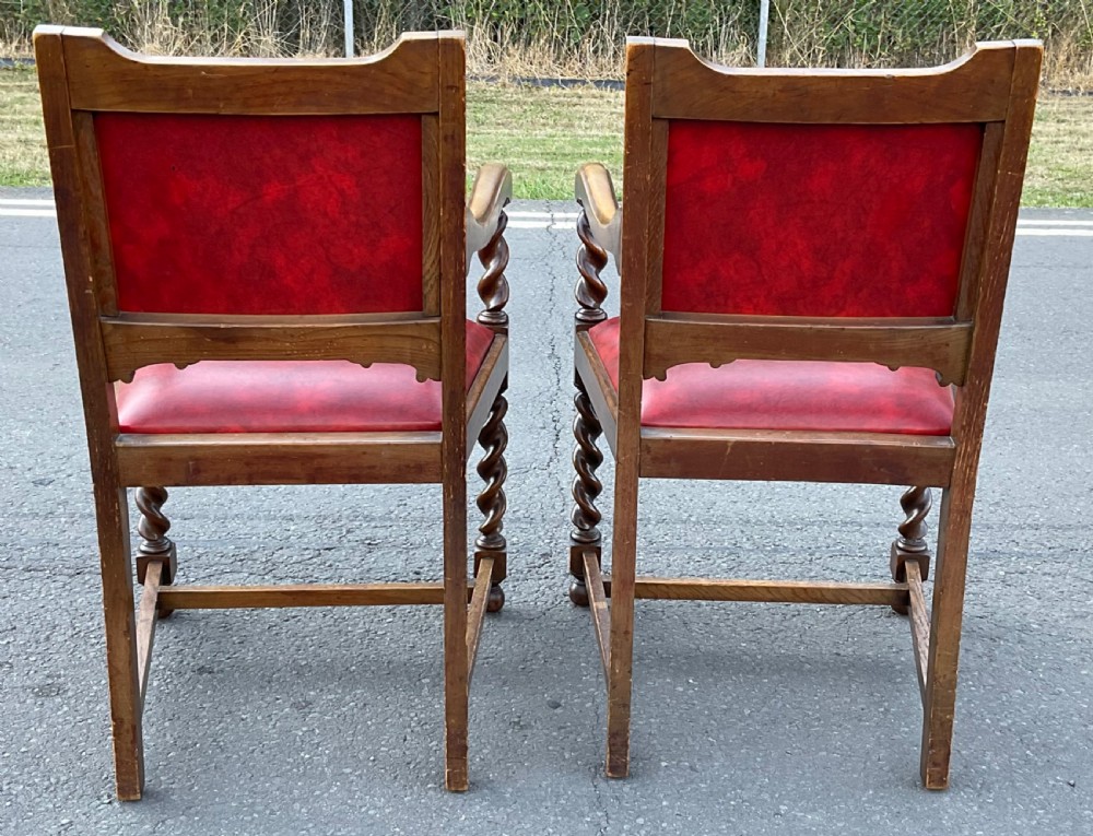 A set of eight oak dining chairs featuring red leather upholstery with brass stud detailing and spiral barley twist legs. View VIII