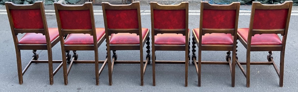 A set of eight oak dining chairs featuring red leather upholstery with brass stud detailing and spiral barley twist legs. View XI