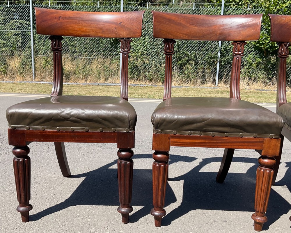 A set of six William IV mahogany dining chairs featuring curved top rails, reeded front legs, and dark green leather upholstered seats. View VIII