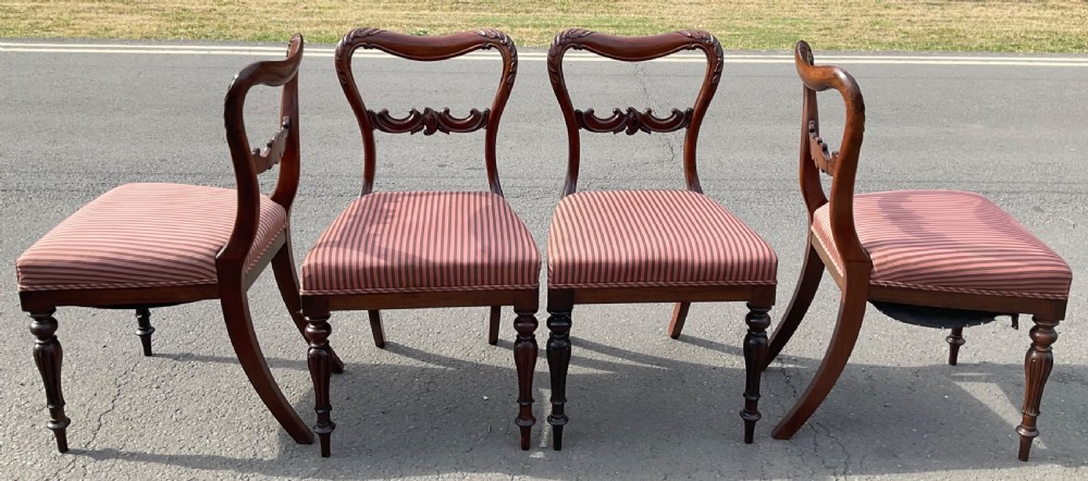 A set of four Victorian rosewood dining chairs featuring carved balloon backs, striped fabric upholstery, and turned front legs. View IX