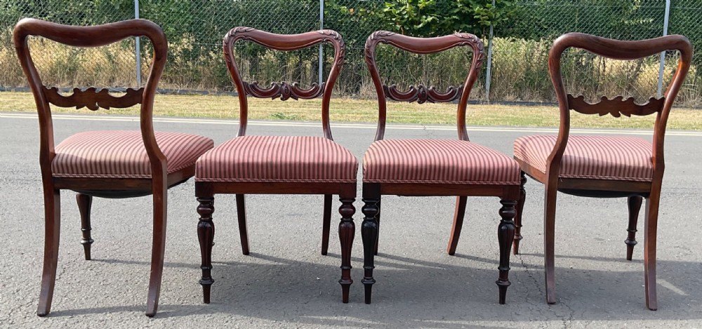 A set of four Victorian rosewood dining chairs featuring carved balloon backs, striped fabric upholstery, and turned front legs. View XI