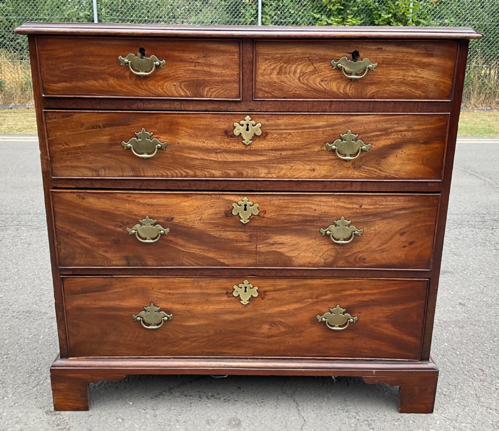 A Georgian mahogany chest of drawers featuring a two short over three long drawer arrangement with brass handles and bracket feet. View II