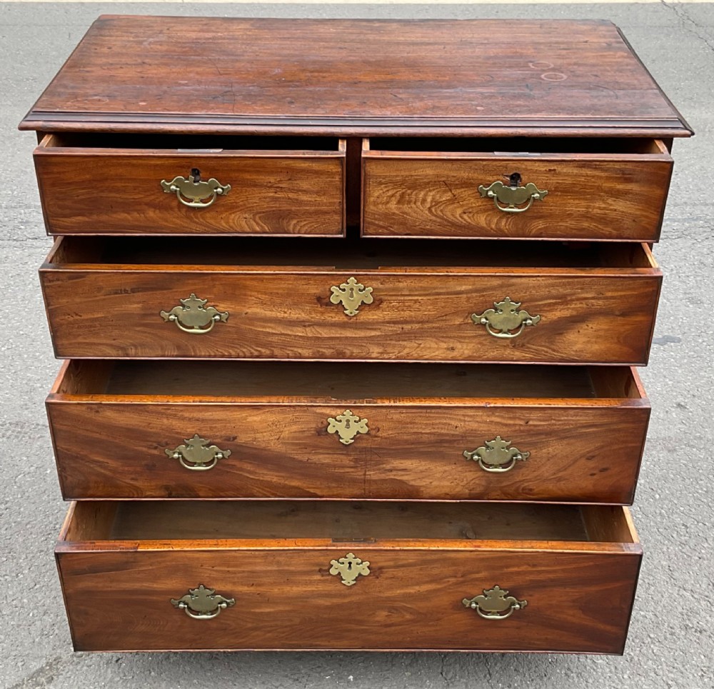 A Georgian mahogany chest of drawers featuring a two short over three long drawer arrangement with brass handles and bracket feet. View X