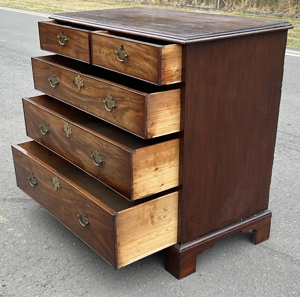 A Georgian mahogany chest of drawers featuring a two short over three long drawer arrangement with brass handles and bracket feet. View XII