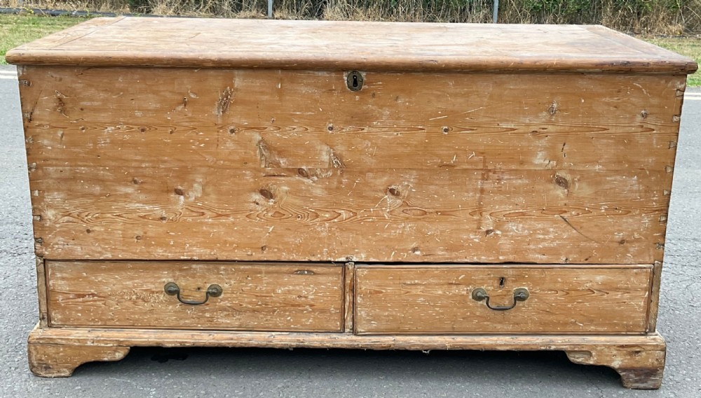 A large Georgian pine mule chest featuring a lift-top storage section above two lower drawers with brass drop handles and bracket feet. View II
