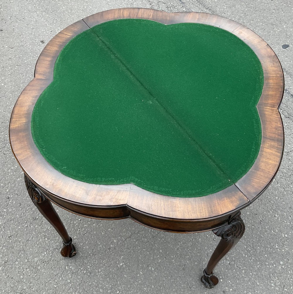 A Queen Anne style walnut foldover card table featuring a shaped top, carved cabriole legs, and claw and ball feet. View VII