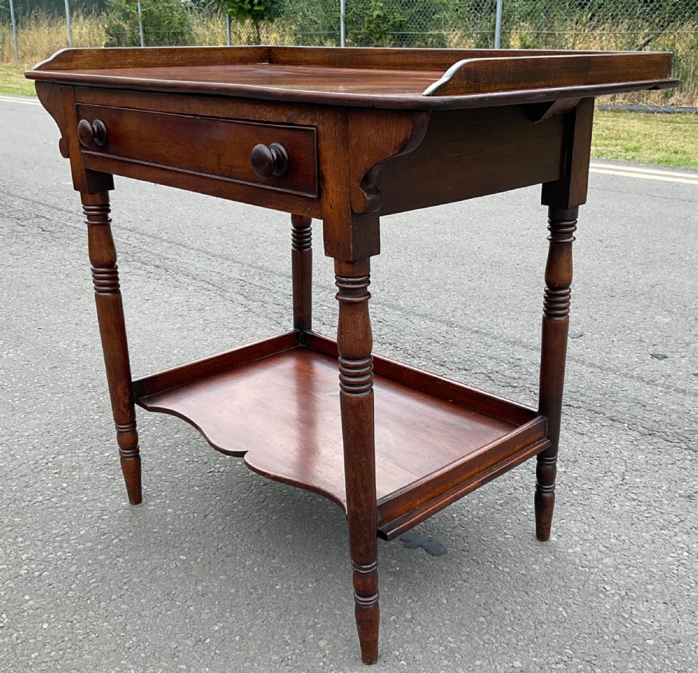 A Victorian mahogany side table featuring a galleried top, single drawer with wooden knobs, turned legs, and a scalloped lower shelf. View II