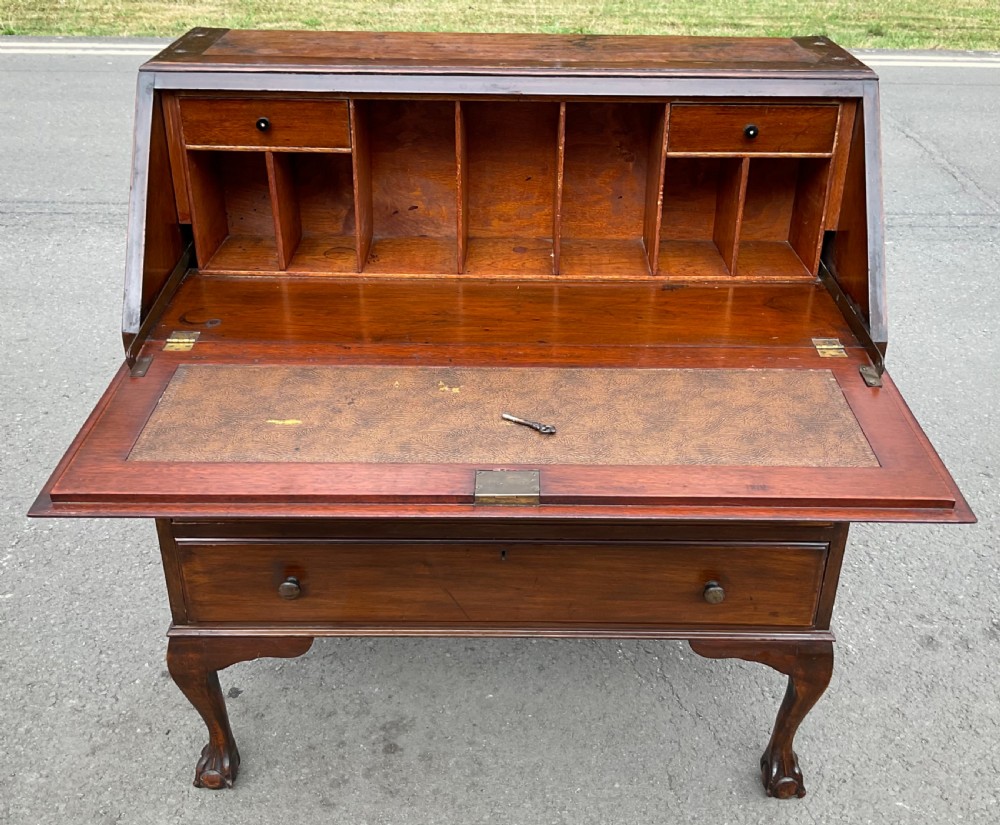 A Chippendale style mahogany bureau bookcase featuring upper glazed doors, a slant-front writing slope, three drawers, and cabriole legs with ball and claw feet. View VI