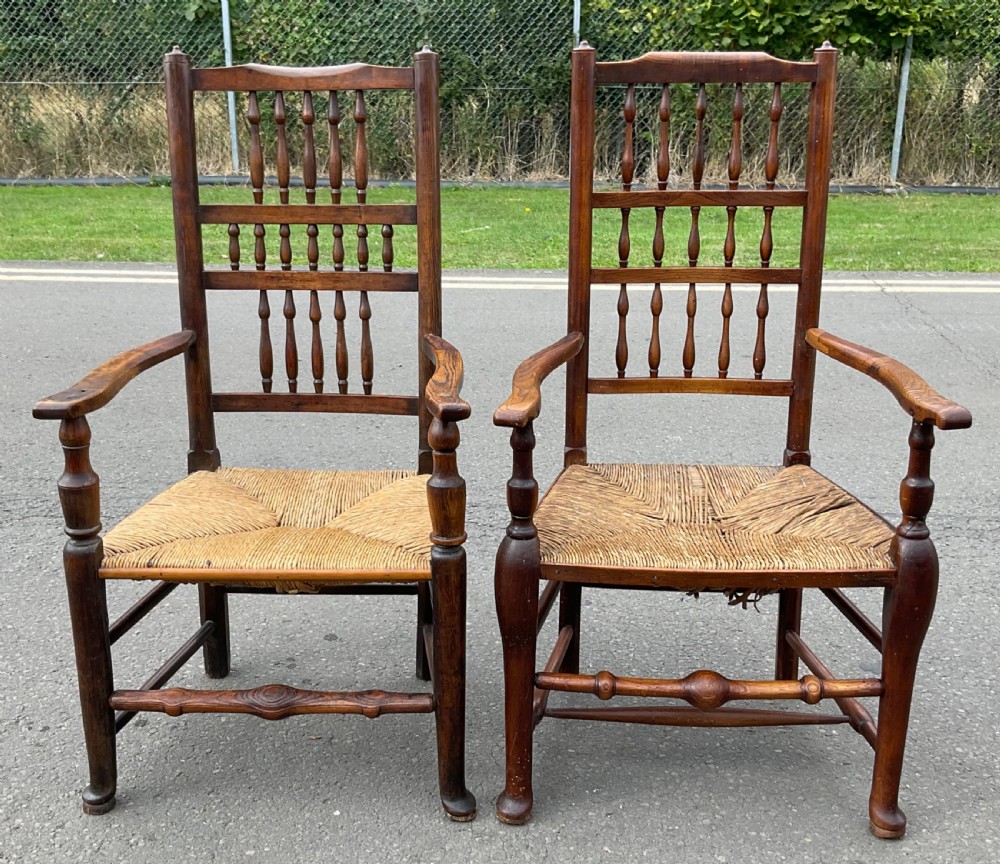 Pair of antique warm brown elm armchairs featuring tiered turned spindle backs and woven rush seats. View II