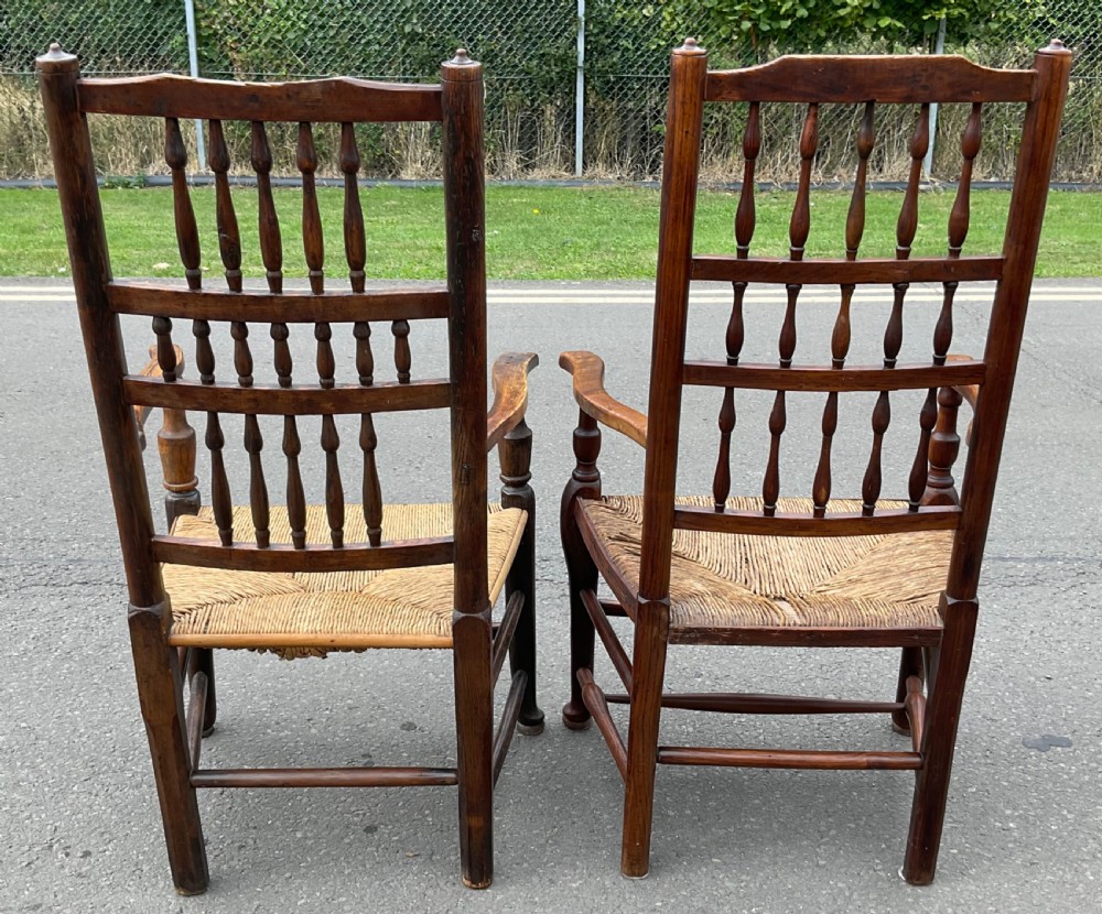 Pair of antique warm brown elm armchairs featuring tiered turned spindle backs and woven rush seats. View VI