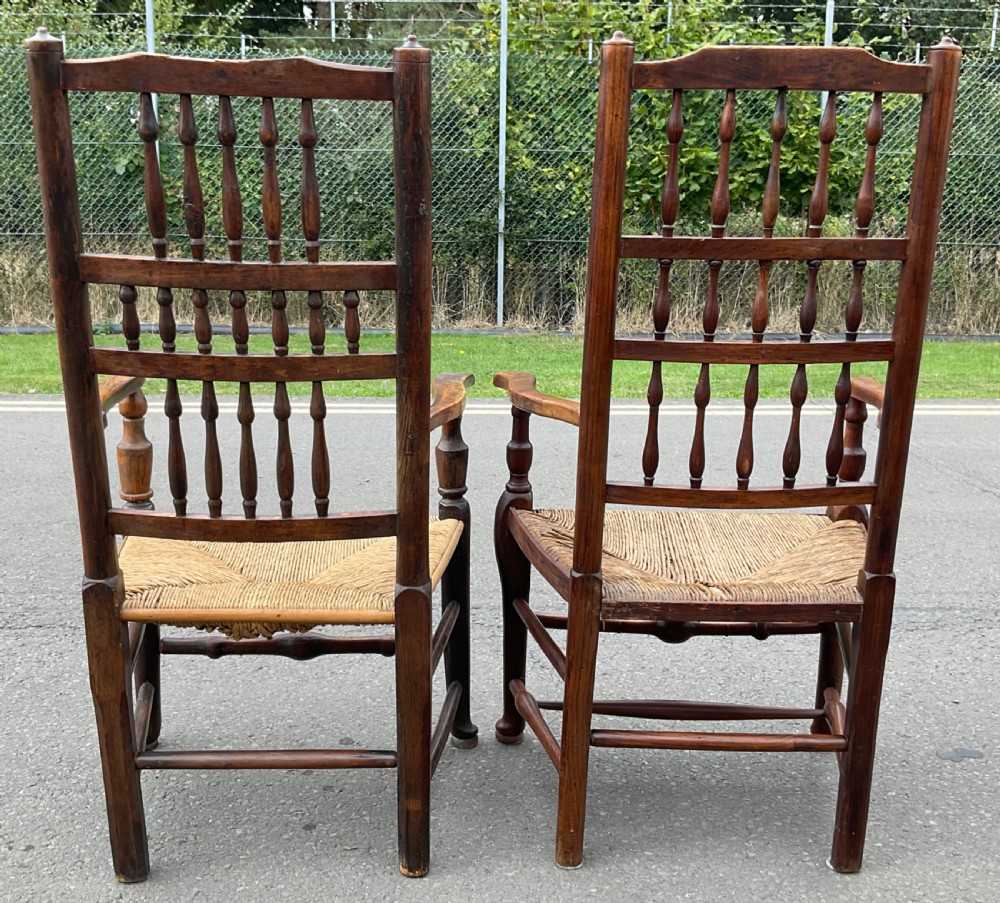 Pair of antique warm brown elm armchairs featuring tiered turned spindle backs and woven rush seats. View VII