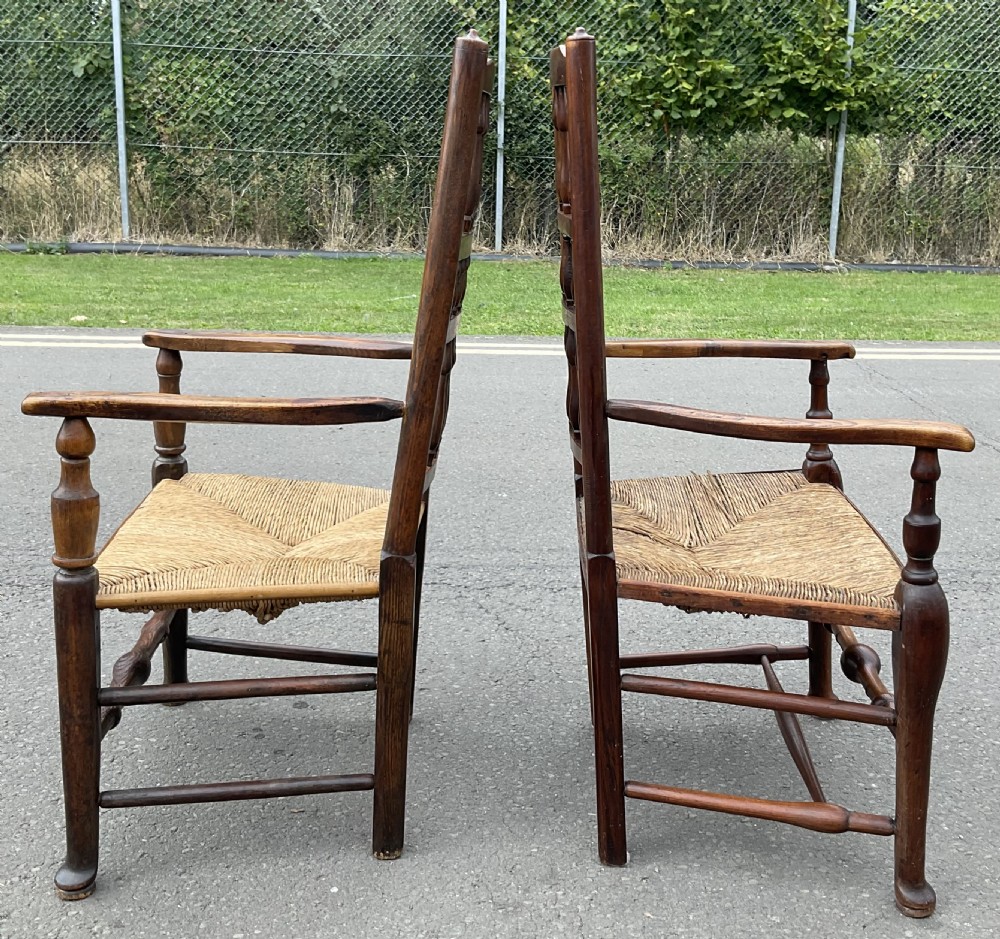 Pair of antique warm brown elm armchairs featuring tiered turned spindle backs and woven rush seats. View VIII
