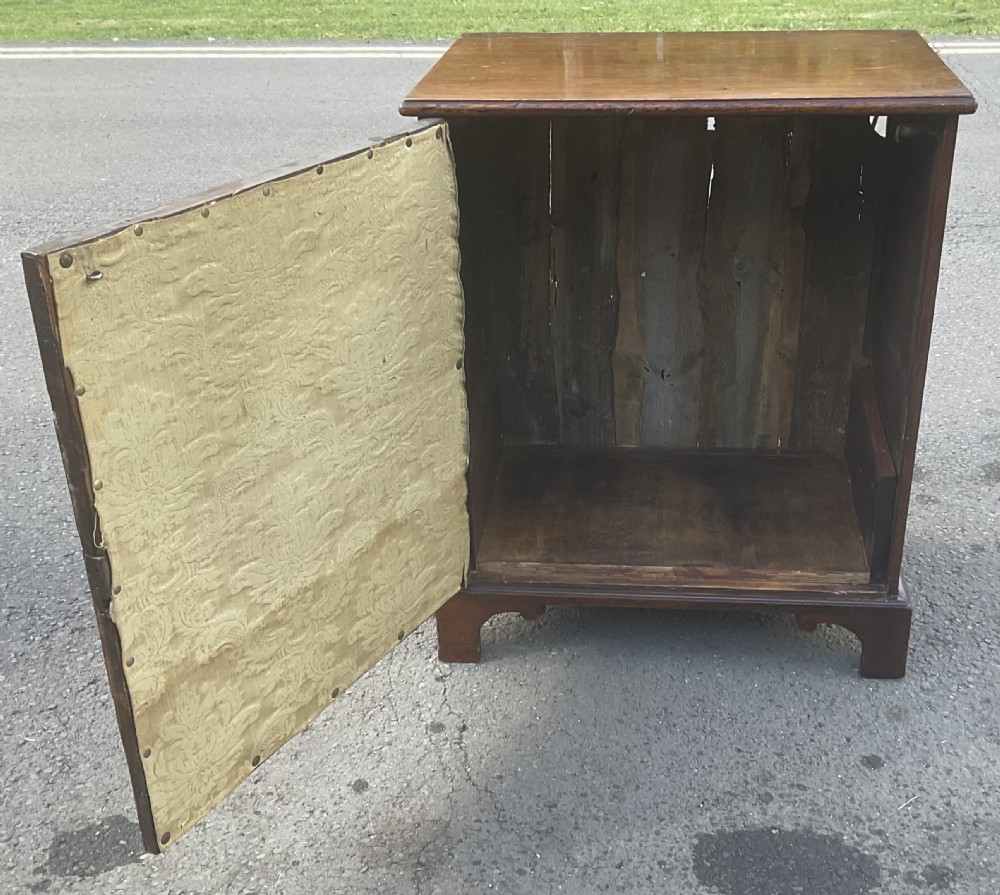 An antique Georgian mahogany side cupboard featuring pressed brass backplate handles, keyhole escutcheons, and bracket feet. View V