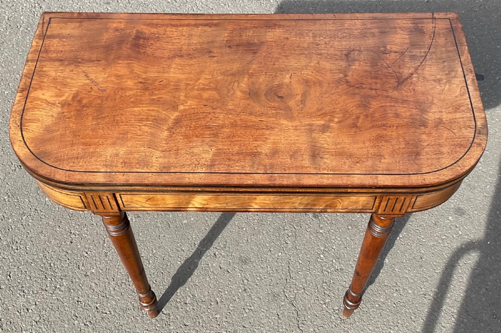 A Georgian mahogany foldover card table featuring line inlay on the frieze and slender turned legs. View II