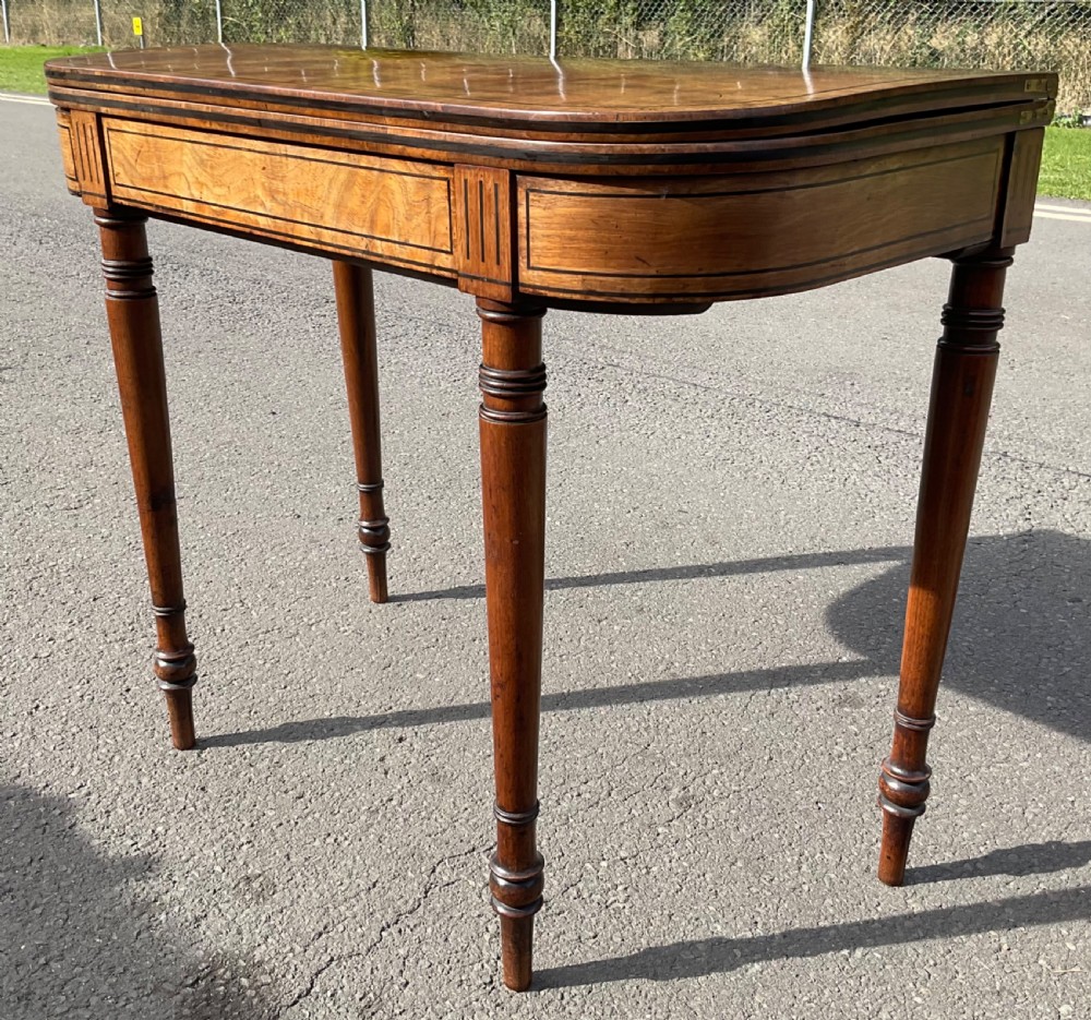 A Georgian mahogany foldover card table featuring line inlay on the frieze and slender turned legs. View III