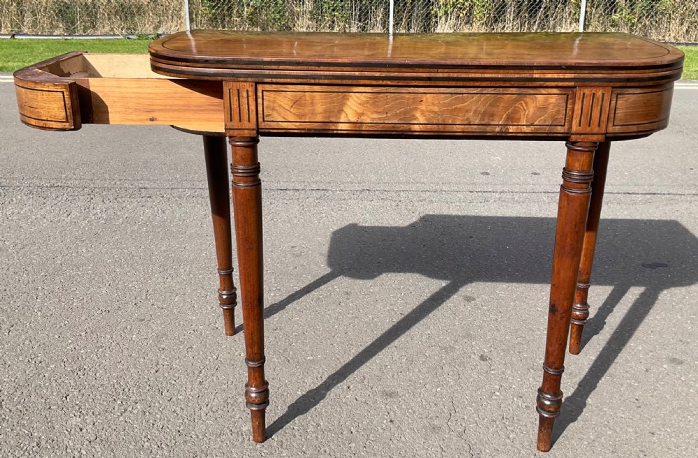 A Georgian mahogany foldover card table featuring line inlay on the frieze and slender turned legs. View IV