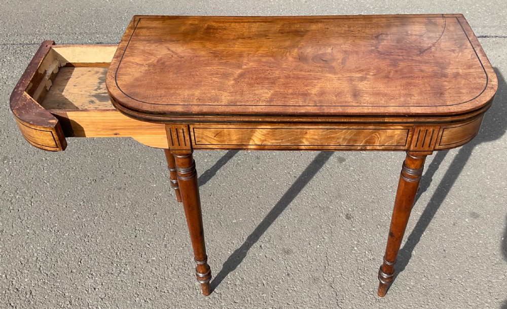 A Georgian mahogany foldover card table featuring line inlay on the frieze and slender turned legs. View V