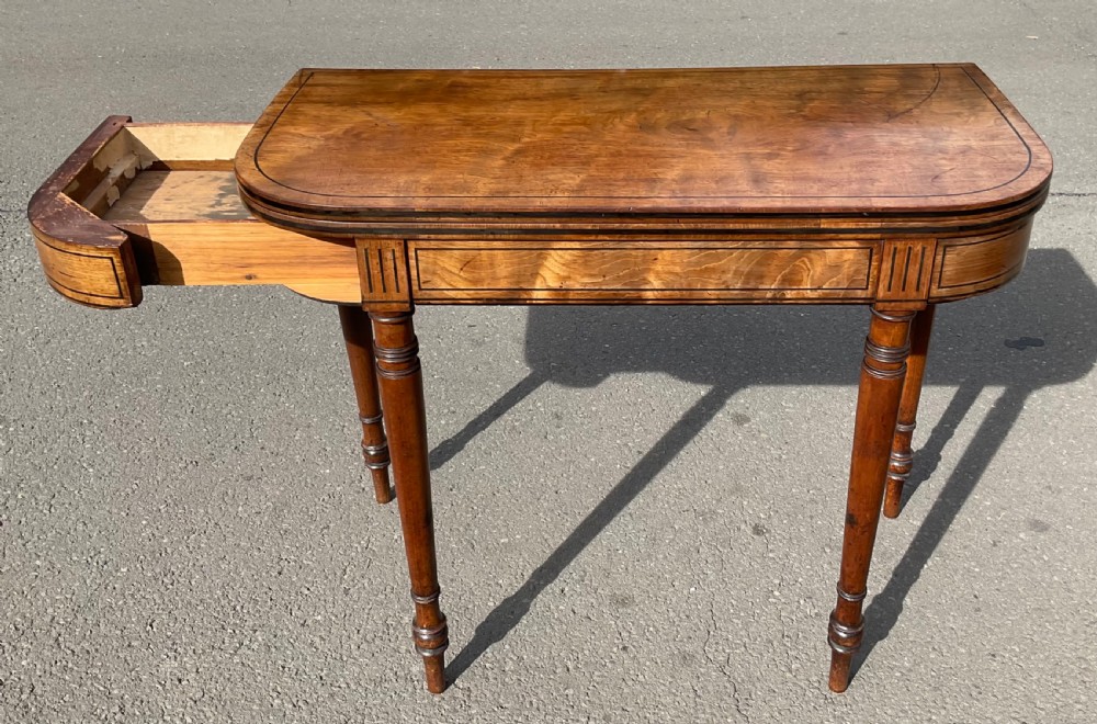 A Georgian mahogany foldover card table featuring line inlay on the frieze and slender turned legs. View VII
