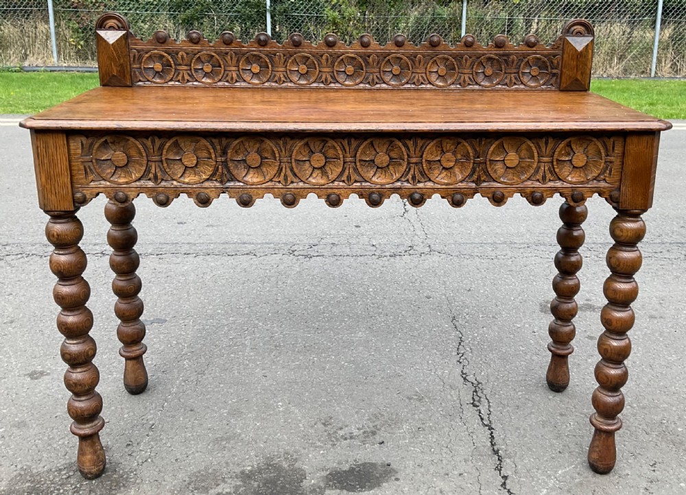 Victorian carved oak side table featuring bobbin turned legs, a carved rosette frieze, and a low decorative gallery back.