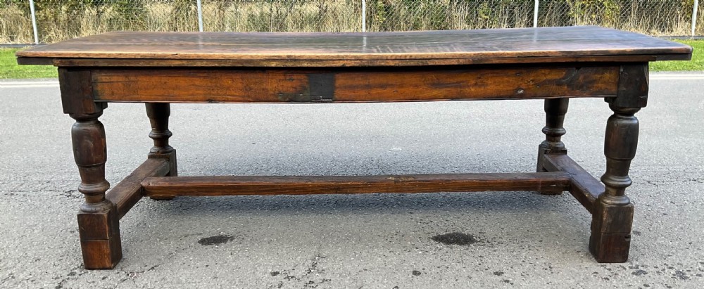 A rectangular antique oak refectory dining table featuring a thick wooden top, turned legs, and a low H-stretcher base. View II
