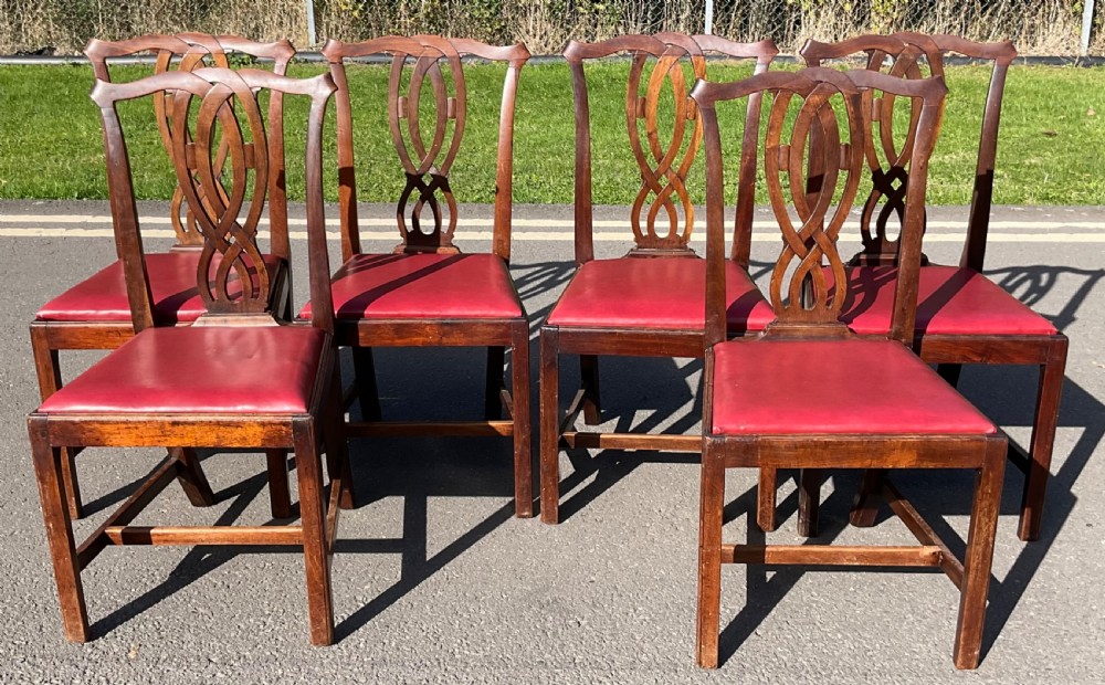 A set of six Georgian mahogany side chairs featuring pierced ribbon-carved back splats, square legs with stretchers, and red leather upholstered seats. View II