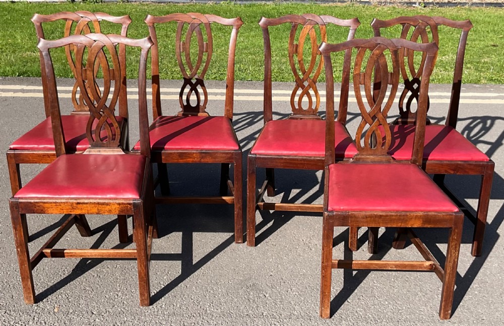 A set of six Georgian mahogany side chairs featuring pierced ribbon-carved back splats, square legs with stretchers, and red leather upholstered seats. View III