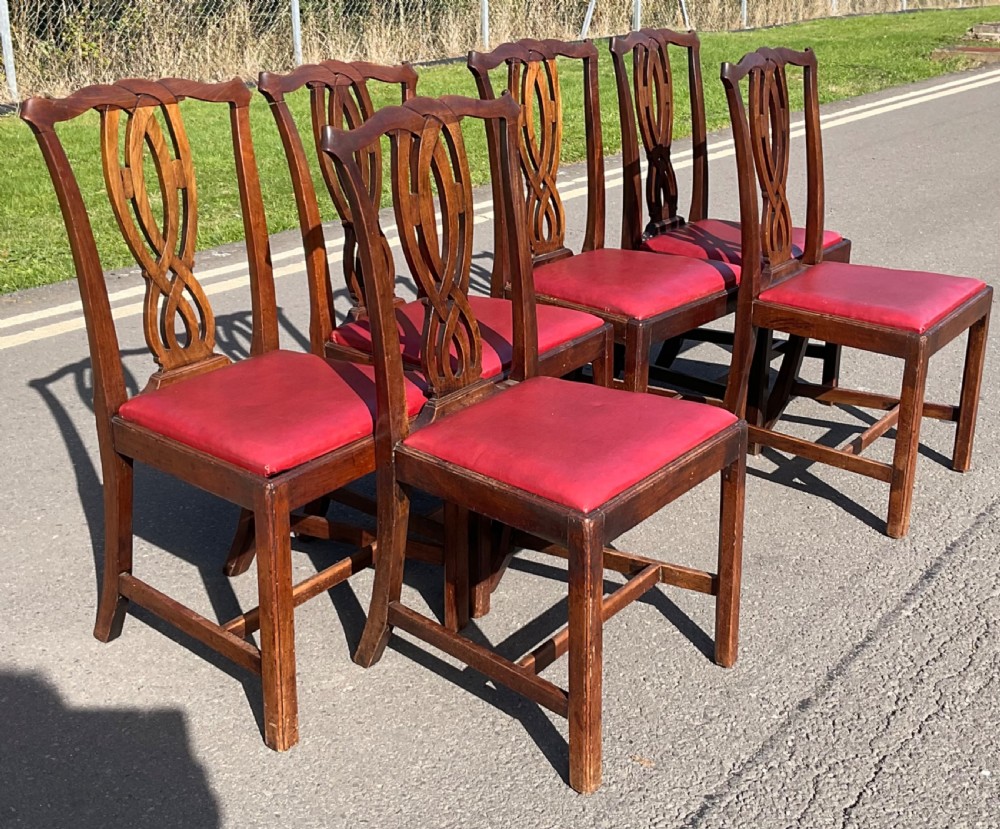 A set of six Georgian mahogany side chairs featuring pierced ribbon-carved back splats, square legs with stretchers, and red leather upholstered seats. View IV