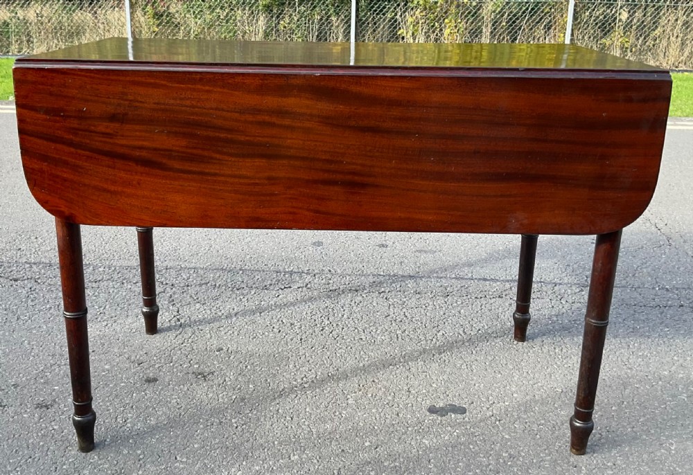 A Georgian mahogany Pembroke table featuring two drop-leaf sides, a single frieze drawer with brass handles, and four turned legs. View III