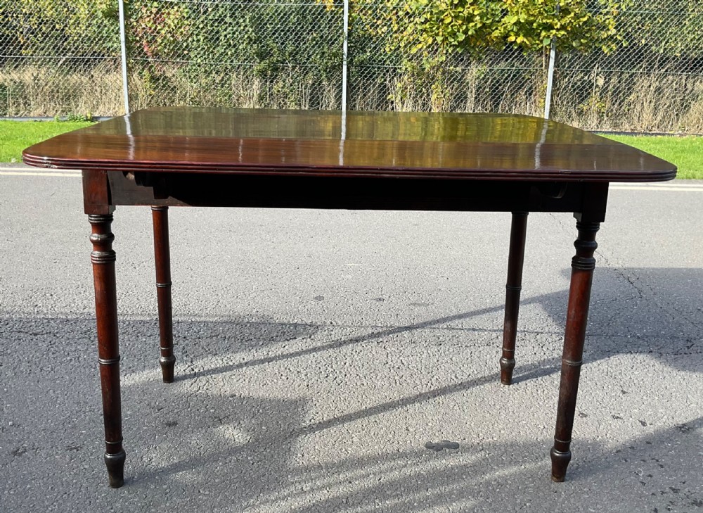 A Georgian mahogany Pembroke table featuring two drop-leaf sides, a single frieze drawer with brass handles, and four turned legs. View IX