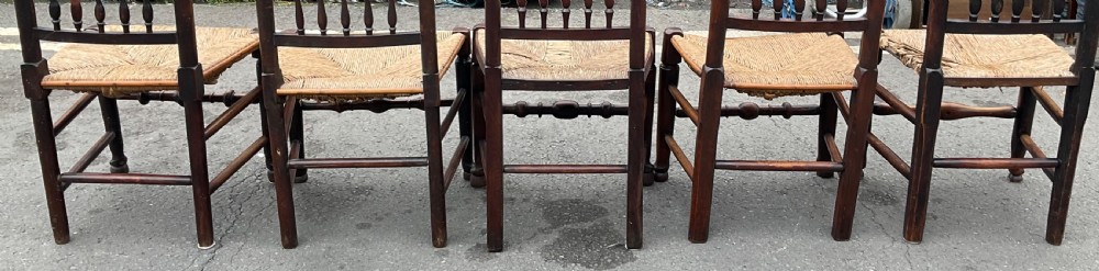 A set of five antique elm Lancashire spindleback dining chairs featuring double-tiered turned back spindles and woven rush seats. View VI