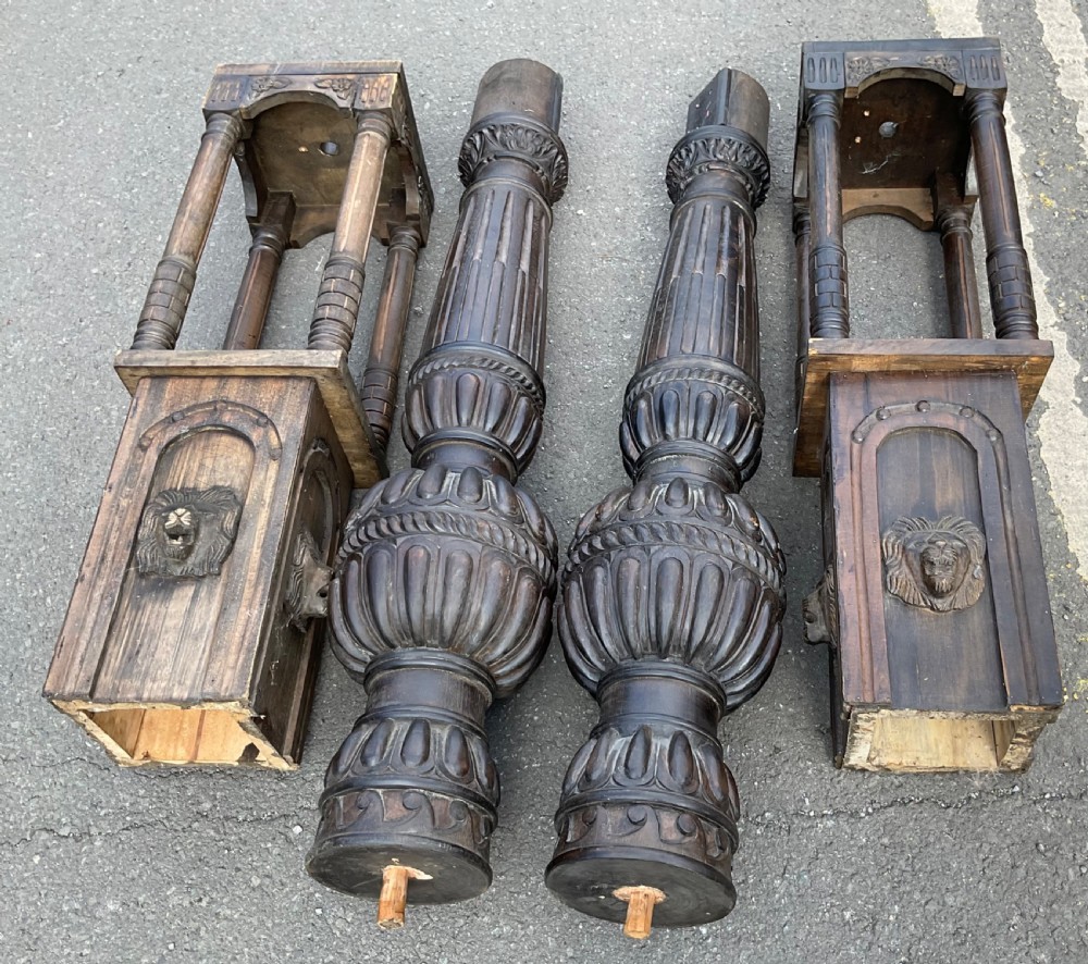 A pair of tall dark carved oak bed posts featuring gadrooned turned balusters, open arcaded sections, and square bases decorated with carved lion masks. View VII