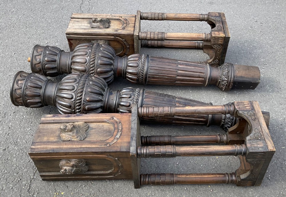 A pair of tall dark carved oak bed posts featuring gadrooned turned balusters, open arcaded sections, and square bases decorated with carved lion masks. View IX