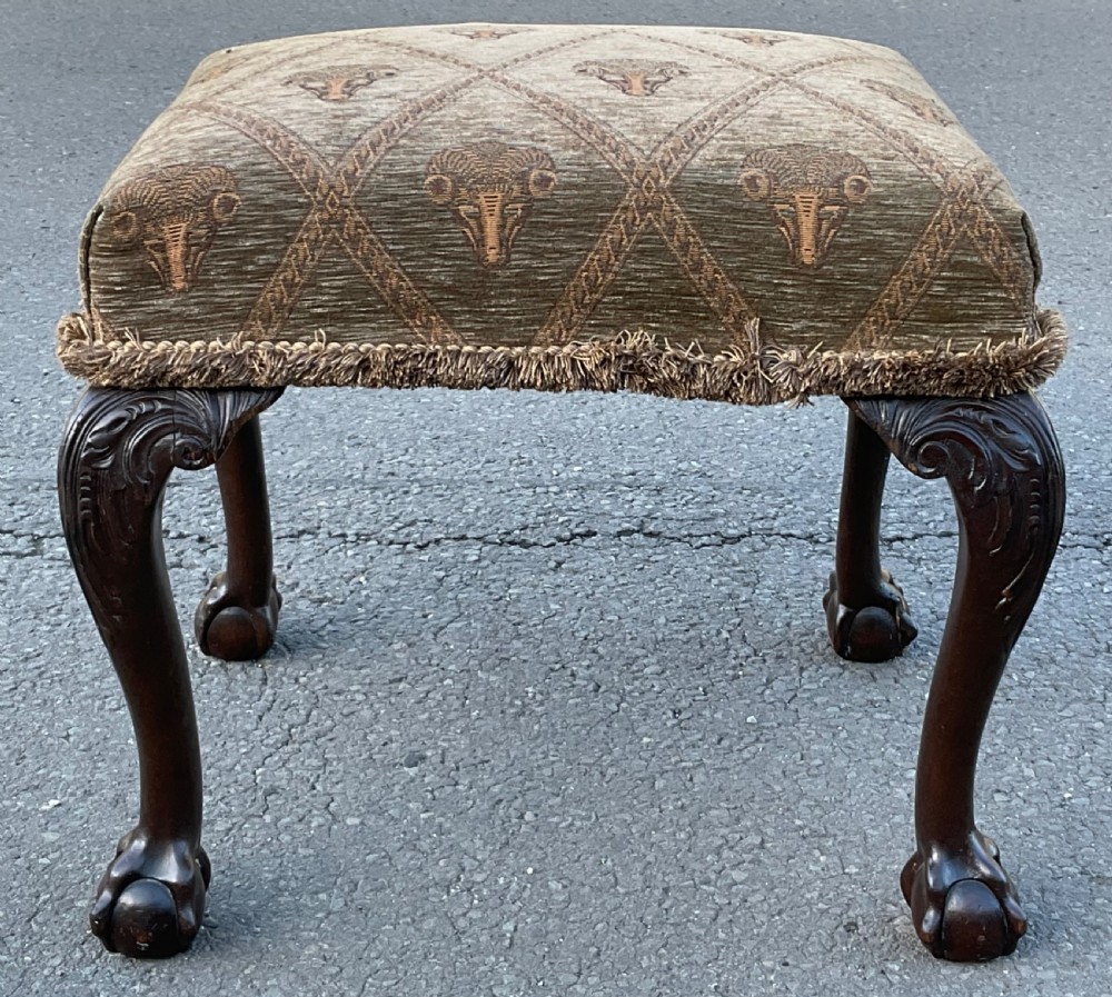 A rectangular Chippendale style mahogany stool featuring cabriole legs with carved knees, ball and claw feet, and pattern-upholstered top trimmed with fringe. View IV