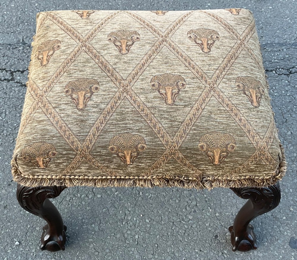 A rectangular Chippendale style mahogany stool featuring cabriole legs with carved knees, ball and claw feet, and pattern-upholstered top trimmed with fringe. View V