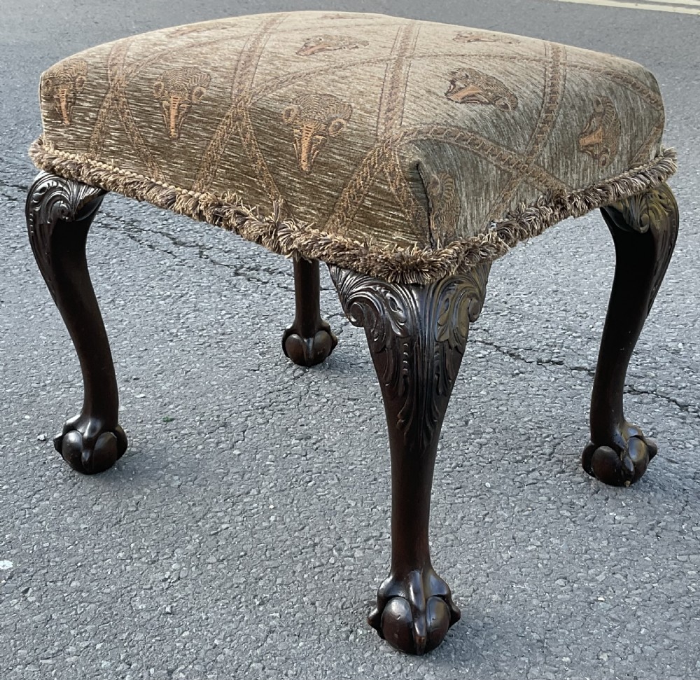 A rectangular Chippendale style mahogany stool featuring cabriole legs with carved knees, ball and claw feet, and pattern-upholstered top trimmed with fringe. View VI